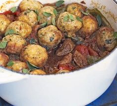 a white bowl filled with meat and vegetables