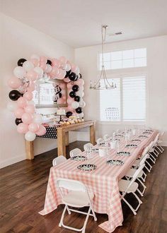 a table set up for a party with pink and black balloons