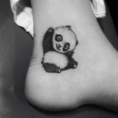 a small panda bear tattoo on the foot