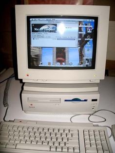 an old desktop computer sitting on top of a desk next to a keyboard and mouse