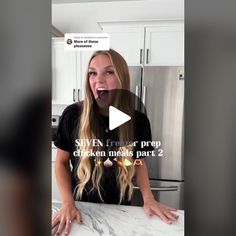 a woman with long blonde hair standing in front of a kitchen counter and talking on the phone