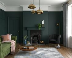 a living room with blue walls and wood flooring, two chairs, a fireplace and a rug on the floor