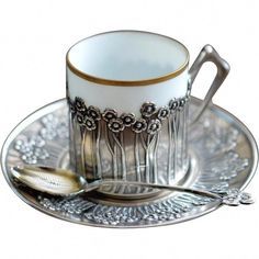 a cup and saucer with spoons on a plate