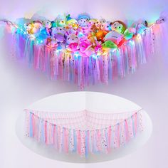 a bunch of stuffed animals are hanging from the ceiling in front of a white wall