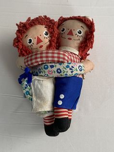 two cloth dolls are holding each other in their arms