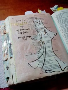 an open bible with a drawing of a woman in a wedding dress on the pages