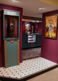 an old fashioned arcade machine in the middle of a room with two paintings on the wall