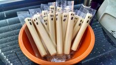 a bowl full of toothpicks with black dots on them sitting on a table