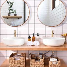 two round mirrors are above the sink in this bathroom with white tiles and wood countertops