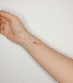 a person's arm with a small tattoo on it