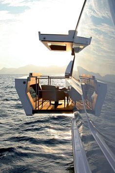 the dining table is on the deck of a boat in the middle of the ocean