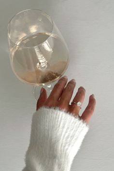 a woman's hand holding up a glass of wine