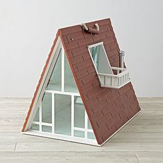 a doll house with a red roof and white windows