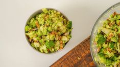 two bowls filled with broccoli on top of a wooden table next to a cutting board