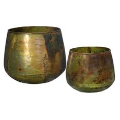 two metal bowls sitting next to each other on a white background, one is green and the other is gold