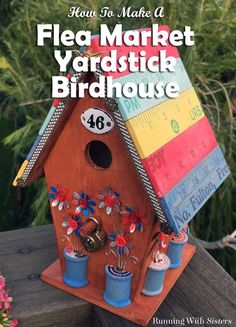 a birdhouse made out of wood with flowers on the roof and words that read flea market yardstick birdhouse