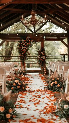 the aisle is decorated with orange flowers and greenery