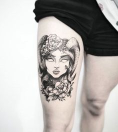 a woman with horns and flowers on her thigh is shown in this black and white photo