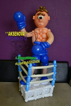 a toy figure is posed on top of an inflatable boxing ring with gloves