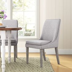 a dining room table with two chairs next to it