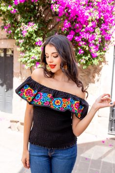 This Beautiful Daisy Embroidered Crop Top is the perfect Top to add to your wardrobe. It's made out of cotton, has an elastic waist and is full of vibrant embroidered florals. This Top is made with love by Mexican Artisans in Guanajuato, Mexico. Black Summer Tops With Intricate Embroidery, Multicolor Embroidered Sleeve Summer Tops, Black Tops With Intricate Embroidery For Summer, Black Embroidered Tops For Summer, Fitted Folk Style Embroidered Top, Fitted Top With Multicolor Geometric Embroidery, Fitted Embroidered Top With Floral Design For Fiesta, Fitted Floral Embroidered Top For Fiesta, Fitted Embroidered Border Top