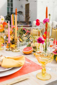 the table is set with candles, plates and fruit for an elegant dinner or brunch