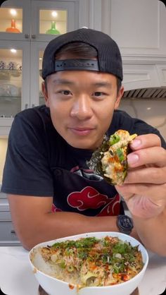 a man is eating food from a bowl on the table in front of his plate