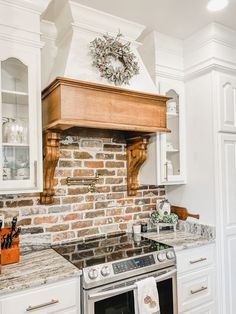 a stove top oven sitting inside of a kitchen next to white cabinets and counter tops