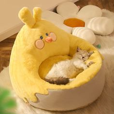 a cat sleeping in a yellow stuffed animal bed