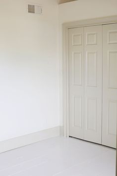 an empty room with white walls and doors