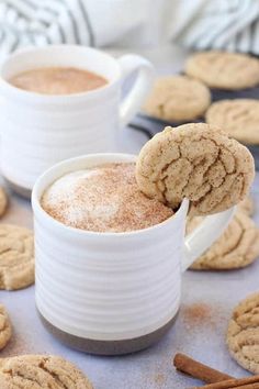 two mugs filled with hot chocolate and cinnamon cookies