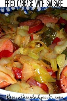 a close up of a bowl of food with sausage and onions in it on a table