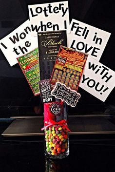 a bottle filled with candy sitting on top of a table next to a sign that says, i won't tell in the love with you