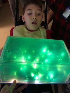 a young boy sitting in a chair with green lights on it