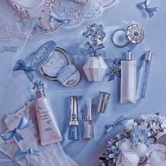 an assortment of personal care items displayed on a blue background with laces and flowers