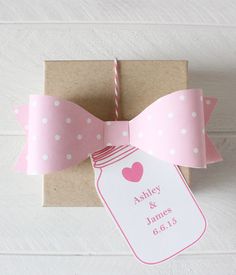 a gift wrapped in brown paper with pink polka dots and a mason jar on it