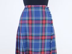 Item Description This is a super cute 100% pure virgin wool wrap skirt with a gorgeous blue background with red green yellow and white plaid details. This has a classic and flattering high rise fit and midi length. I love the simple a line cut as well. The skirt has button closures at the waist, and matching fabric buttons down the side to keep the wrap together while wearing it. The skirt has a unique design where the front is flat but the sides and back are pleated at the waist. The skirt is n Scottish Style Fitted Skirt For School, Scottish Fitted Skirt For School, Fitted Scottish Skirt For School, Wool Wrap Skirt, Fabric Buttons, Wool Wrap, Red Green Yellow, White Plaid, Wrap Skirt