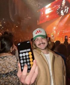 a man holding up a remote control in front of a crowd