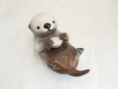 a glass figurine of a bear holding something in it's paws on a white surface