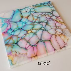 a square tile with multicolored marbled design on it's sides and bottom