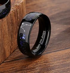 a black ring with blue stars on it sitting next to a wooden block that says, i love you