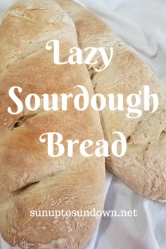 two loaves of sourdough bread sitting on top of a white cloth with the words lazy sourdough bread