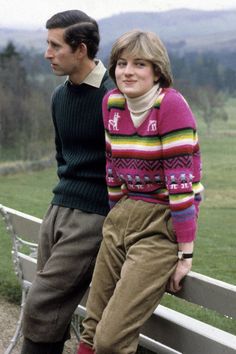 two people sitting on a bench in front of a field