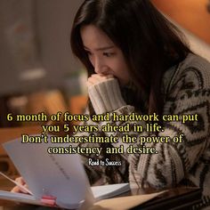 a woman sitting at a desk with her hand on her chin and looking at a piece of paper