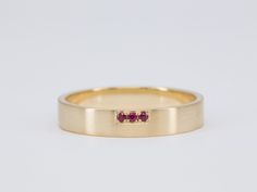 a yellow gold ring with three ruby stones