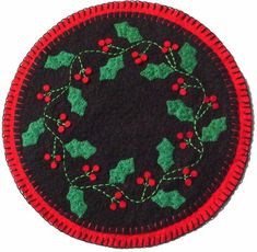 a black and red christmas ornament with holly berries on the center is shown