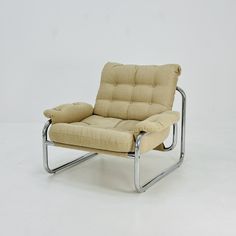 a chair that is sitting on some kind of metal frame with a beige fabric upholstered seat