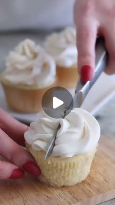 a person cutting into cupcakes with a knife