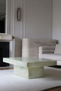 a living room with white furniture and a fireplace