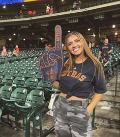 a woman holding up a baseball bat in a stadium